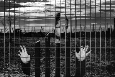 Artistic photo of a man trapped behind a fence